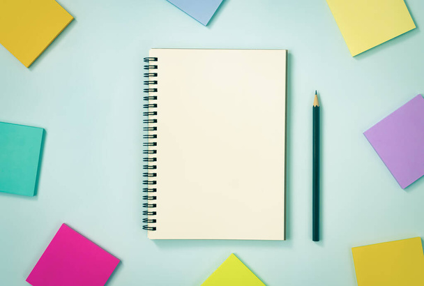 Spirál Notebook vagy tavaszi Notebook Unline Type és Multi Color Sticky Note és ceruza kék pasztell minimalista háttér. Spirál Notebook Mockup a Center Frame-en a Vintage Tone-ban - Fotó, kép
