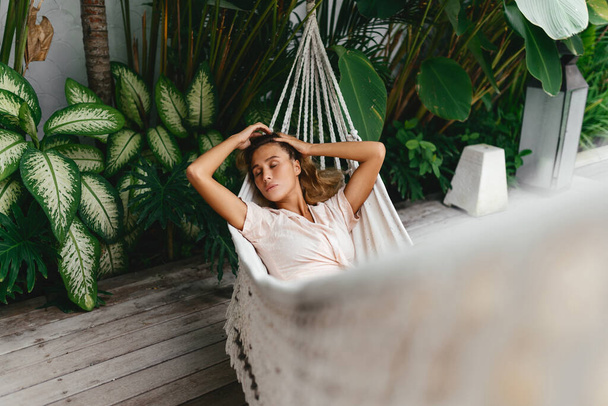 Young beautiful woman relaxing in hammock - Foto, imagen