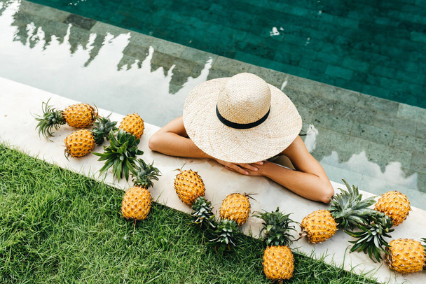 Beautiful Woman Relaxing In Swimming Pool With Pineapples. Healthy Lifestyle, Nutrition, Diet. Summer Vacation - Foto, imagen