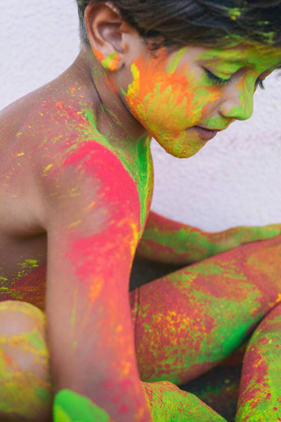 Портрет дитини з кольорами на обличчі. Портрет милої дитини в кольорових порошках під час Холі
 - Фото, зображення