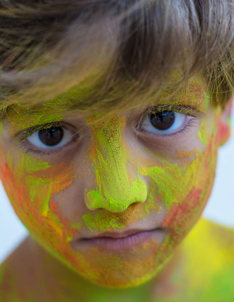 Портрет дитини з кольорами на обличчі. Портрет милої дитини в кольорових порошках під час Холі
 - Фото, зображення