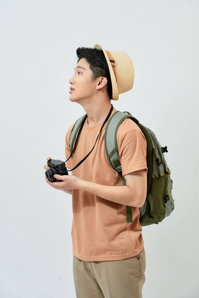 Portré vidám fiatal ázsiai turista férfi kezében digitális fényképezőgép és fotózás, amikor áll a fehér háttér. - Fotó, kép