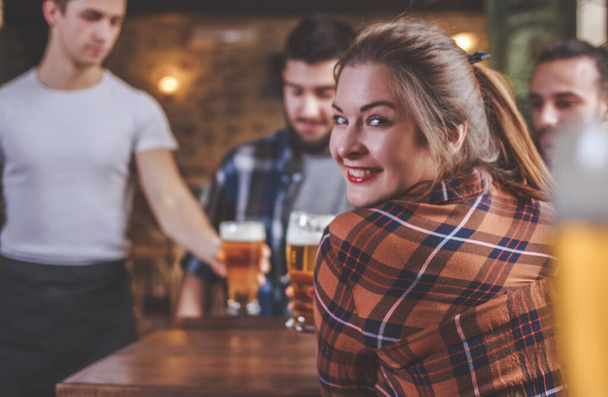 Barda veya barda arkadaşlarıyla bira içen bir kadın. - Fotoğraf, Görsel