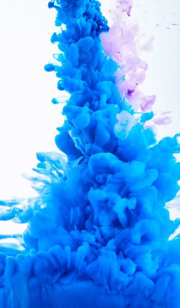 Kleurrijke abstracte schilderkunst Acrylverf achtergrond textuur in water creëert een interessante abstractie op een witte achtergrond. Spray van blauwe kleuren. - Foto, afbeelding