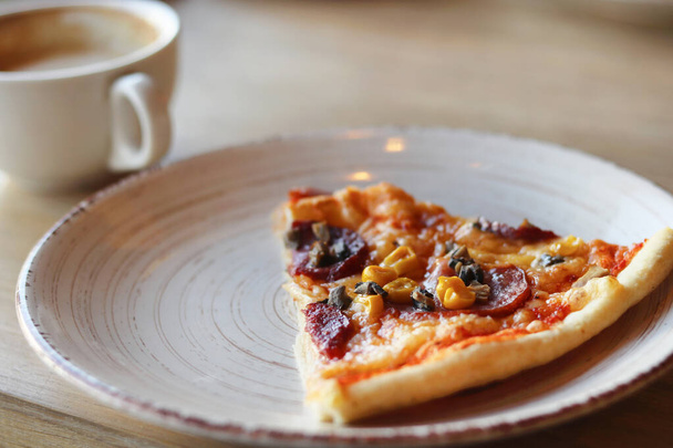Finom forró pizza egy fából készült tányéron. Kicserélt evőeszközök, egy csésze kávé. Másolás tér - koncepció kávézó élelmiszer, rend, szolgáltatás, étvágy, reklám - Fotó, kép