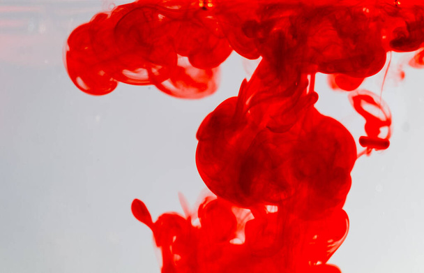 out of focus red ink drop in crystal clear water, soft focus of red ink in clear water, - 写真・画像