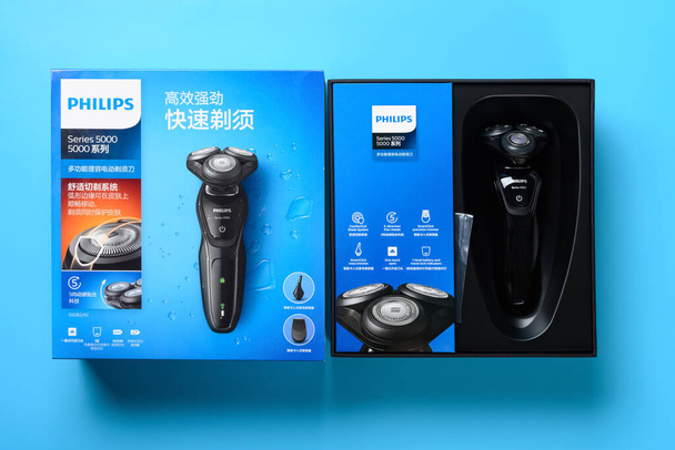 ZhongShan China-agosto 28 2020: caja de vista superior de la máquina de afeitar eléctrica a estrenar sobre un fondo azul. - Foto, Imagen