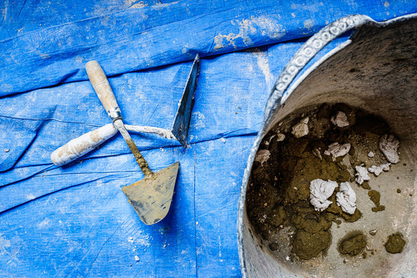 Les décombres d'une maçonnerie travaillent sur un chiffon protecteur bleu, personne. - Photo, image