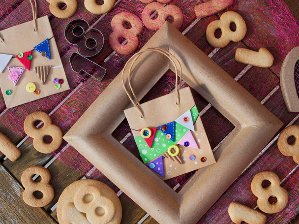 bag decorated with garlands typical of birthday parties. Handicrafts. 18th anniversary. Butter cookies. - Photo, Image