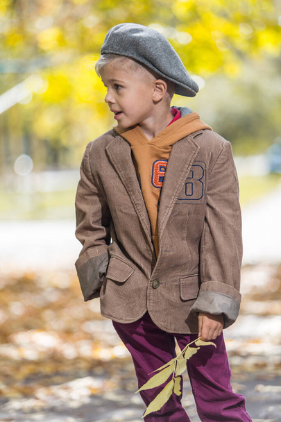 Cute little boy in autumn outfit over yellow background - Fotoğraf, Görsel