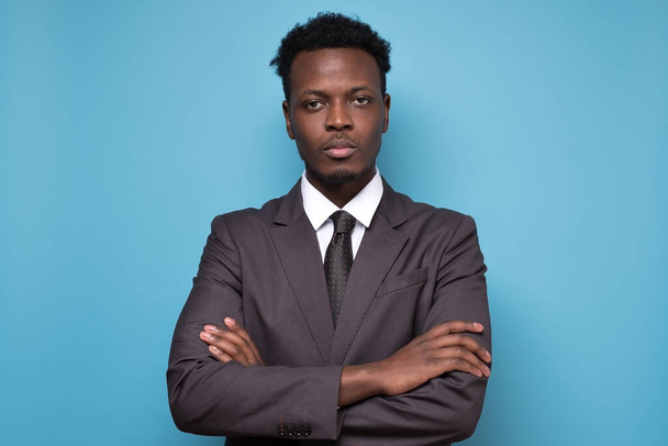 Studio portrét vážně pohledného mladého afrického podnikatele v obleku a kravatě. Izolováno na gblue pozadí - Fotografie, Obrázek