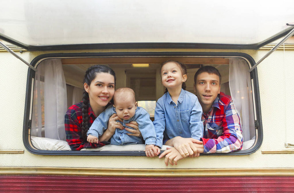 Porträt der lächelnden glücklichen Familie mit Kindern im Haus auf Rädern - Foto, Bild
