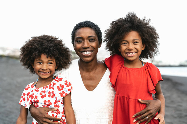 Glückliche afrikanische Familie, die sich in den Sommerferien am Strand vergnügt - Portrait von Afroamerikanern, die ihre Urlaubstage genießen - Elternliebe und Reiselebensstil-Konzept - Foto, Bild