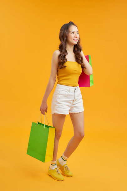 Krásná módní půvabná fena s nákupními taškami v rukou kráčí po obchodech - Fotografie, Obrázek