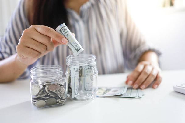 Εξοικονόμηση χρημάτων έννοια Οικονομική γυναίκα χέρι στοίβα κέρματα χρήματα χρήματα αυξάνεται επιχείρηση. μετρητά σε τραπεζογραμμάτια σε δολάρια - Φωτογραφία, εικόνα