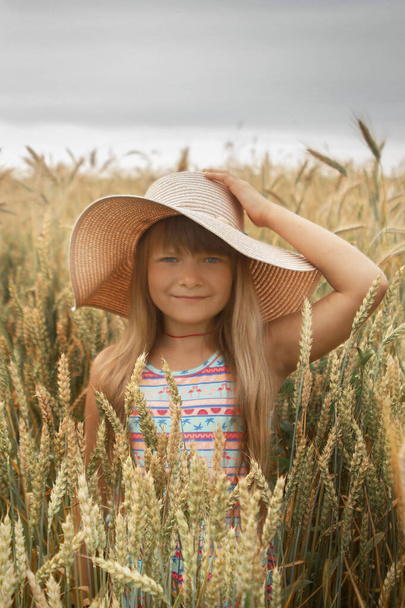 Girl in a hat in a whead field - Фото, изображение