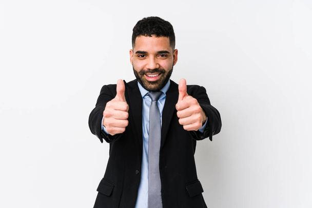 Young latin business woman against a white background isolated with thumbs ups, cheers about something, support and respect concept. - Photo, Image