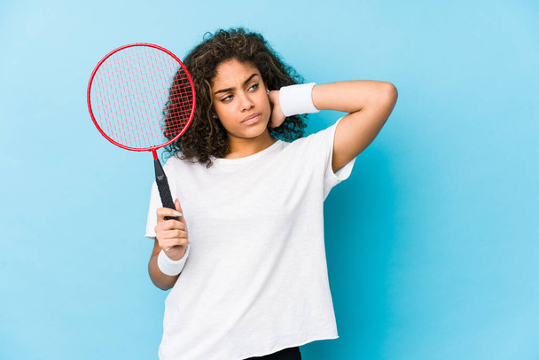 Mladá africká americká žena hrající badminton dotýkající se týla hlavy, přemýšlející a činící rozhodnutí. - Fotografie, Obrázek