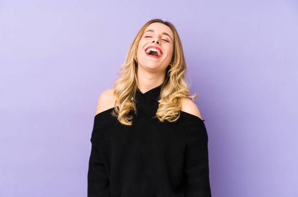 Young blonde woman isolated relaxed and happy laughing, neck stretched showing teeth. - Zdjęcie, obraz