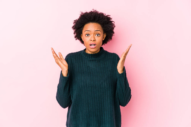 Middle aged african american woman against a pink background isolated surprised and shocked. - Photo, Image