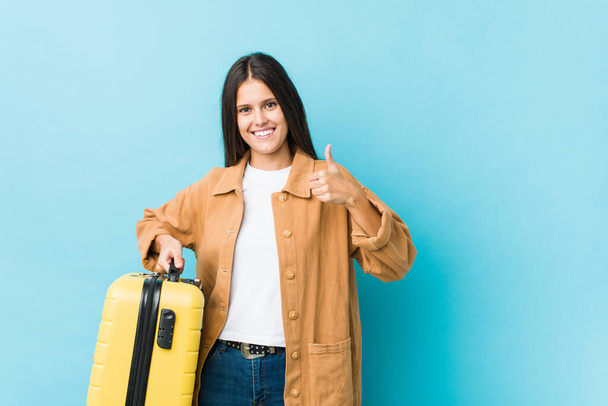 Young caucasian woman holding a suitcase smiling and raising thumb up - Photo, Image