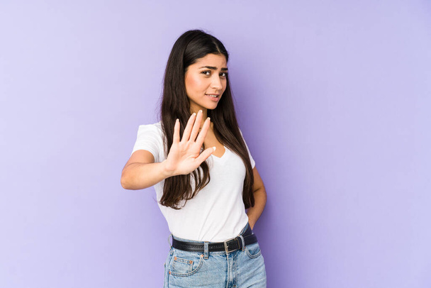 Young indian woman isolated on purple background rejecting someone showing a gesture of disgust. - Photo, Image