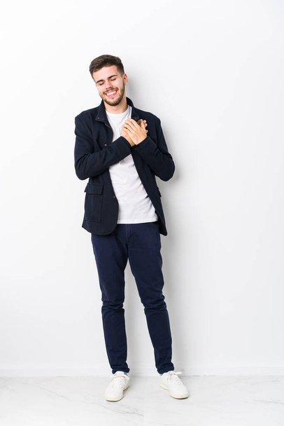 Full body young caucasian man isolated laughing keeping hands on heart, concept of happiness. - Foto, Imagem