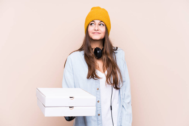 Kafkasyalı genç bir kadın, hedeflerine ve amaçlarına ulaşma hayalleri kurarak pizzaları soyutlamış. - Fotoğraf, Görsel