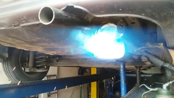 Soldadura de color verde para reparar un tubo de expulsin de gases de un carro  - Imágenes, Vídeo