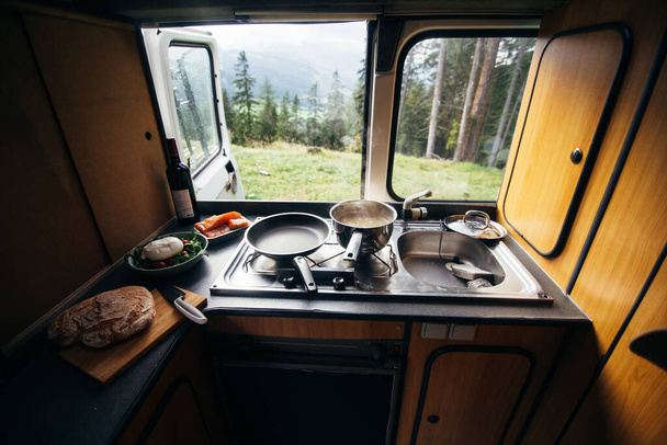 Interior of camper van with kitchen and view - 写真・画像