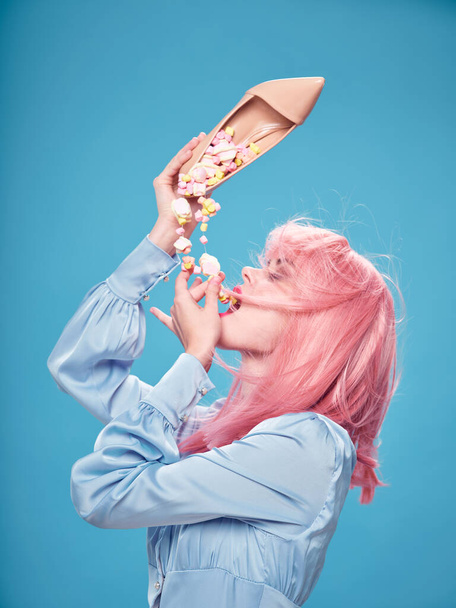 Frau isst Süßigkeiten Schuh in der Hand rosa Haar Dessert Essen Diät  - Foto, Bild