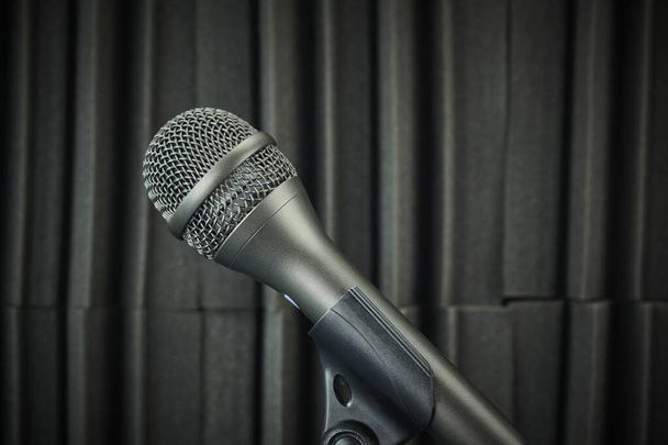 Boční pohled mikrofon namontovaný na stojanu mikrofonu a akustické pěny pozadí v šedých tónech - Fotografie, Obrázek
