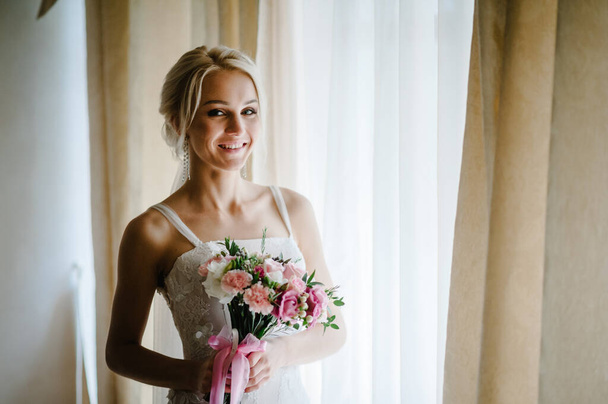 Young attractive bride with flowers. - Фото, изображение