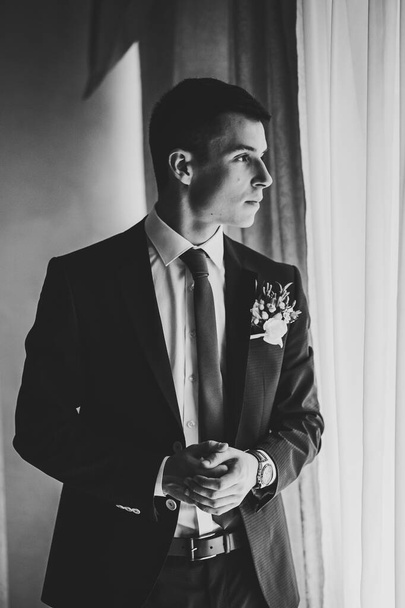 Portrait of a beautiful young groom. Tender emotion on the face. Black and white photo. - Photo, Image