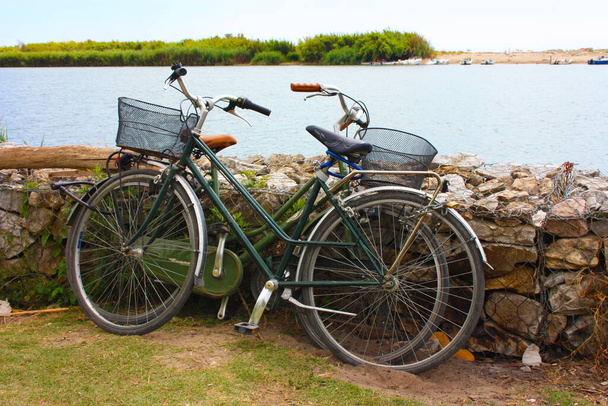 estacionar duas bicicletas encostadas a uma parede de pedra para desfrutar das suas férias junto ao mar na Toscana - Foto, Imagem