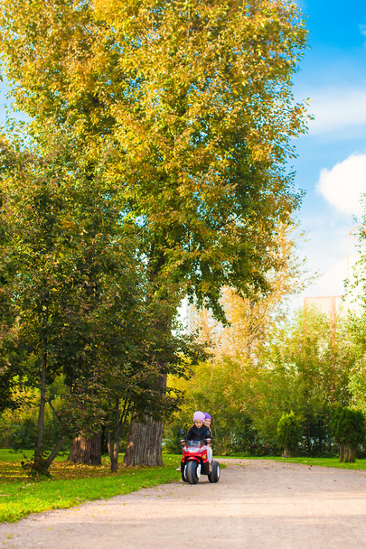 aranyos kislány gyerek motobike a zöld Park lovaglás - Fotó, kép