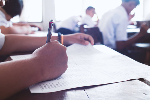 Студенты пишут и сдают экзамены со стрессом в классе. - Фото, изображение