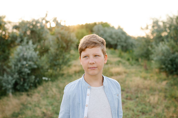 Portrait of a teen boy outside. yYung boy enjoys his time outside in the field - Fotoğraf, Görsel