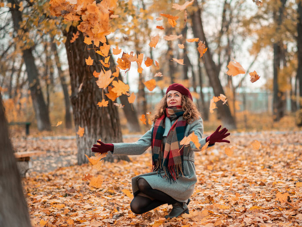 Мечтательная красивая девушка с естественными красивыми волосами на осеннем фоне с красочными листьями. - Фото, изображение