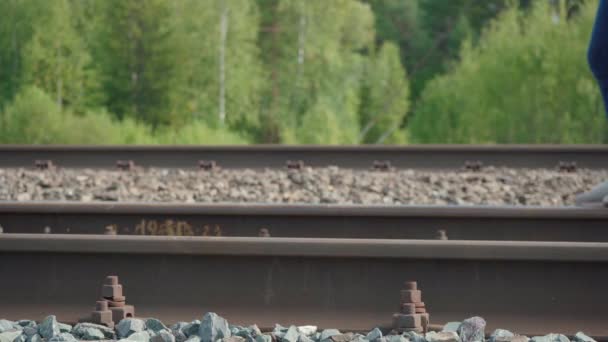 Filmación de la mujer caminando en el ferrocarril en el verano - Imágenes, Vídeo