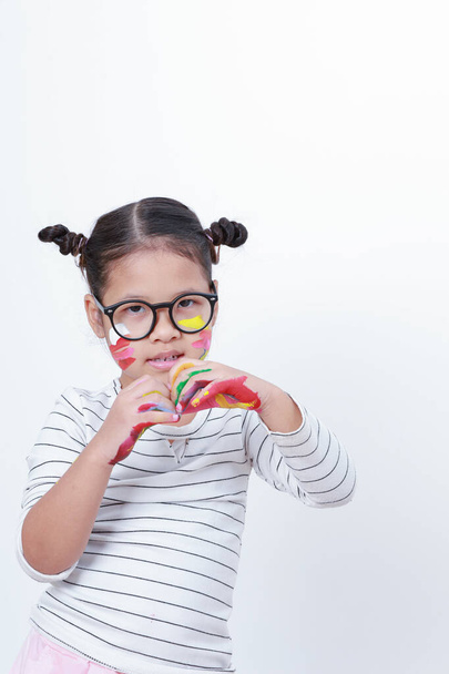 Asian kid wearing glasses looking at a camera. She made a heart-shaped hand on a white background with copy space. - Photo, image