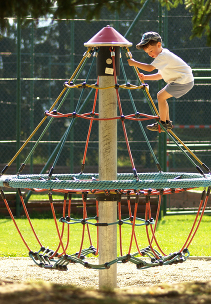 Boy climbing on monkey bars at the playground - Zdjęcie, obraz