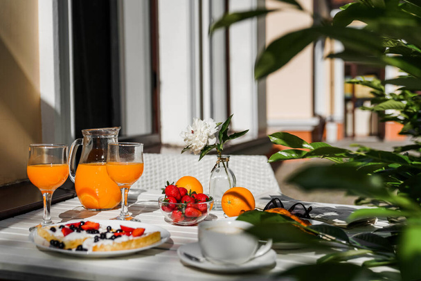 Kontinentales Frühstück im Hotel auf der Terrasse. Orangen Saft belgische Waffeln mit Früchten - Foto, Bild