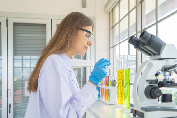 Batılı bir bilim kadını laboratuvar, kimya, sağlık ve araştırma laboratuarında kovid-19 virüsü aşısı üzerinde çalışıyor ve geliştiriyor. Deneysel bilim. - Fotoğraf, Görsel