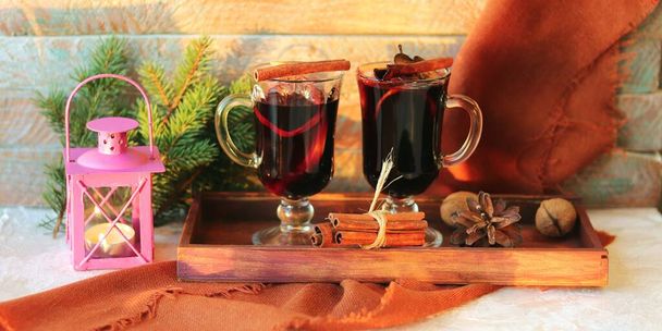 Veselé Vánoce, poháry se svařeným vínem, koření na dřevěném podnosu, jedlové větve, lucerna se svíčkou na lehkém stolku, koncept pohodlí domova, sezónní zimní prázdniny - Fotografie, Obrázek
