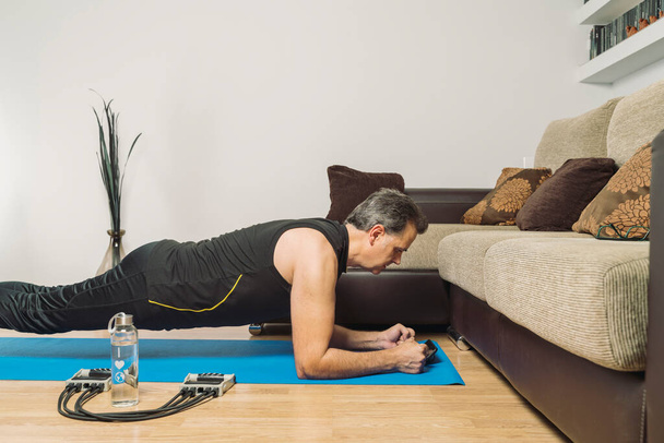Mature European Caucasian male exercising at home. home training. social distancing - Фото, изображение