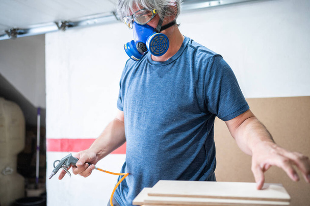 Homme avec masque anti-poussière travaillant dans son atelier. - Photo, image