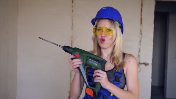 Positieve vrouwelijke bouwvakker met een elektrische ponsmachine. Blondbouwer - Video
