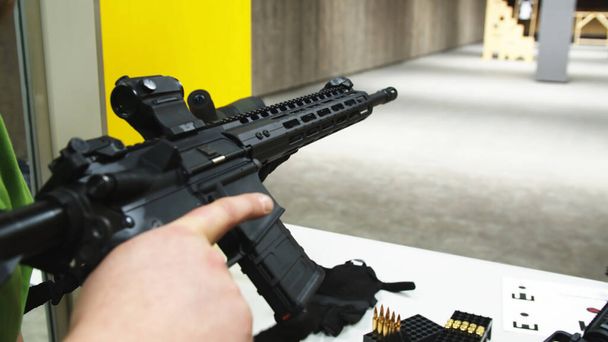 Adulto carregando um rifle de assalto em um campo de tiro. - Foto, Imagem