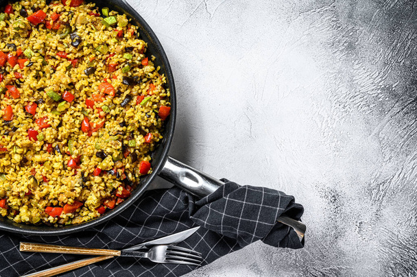 Cooked bulgur with vegetables and chicken meat in a pan. Gray background. Top view. Copy space. - Photo, Image